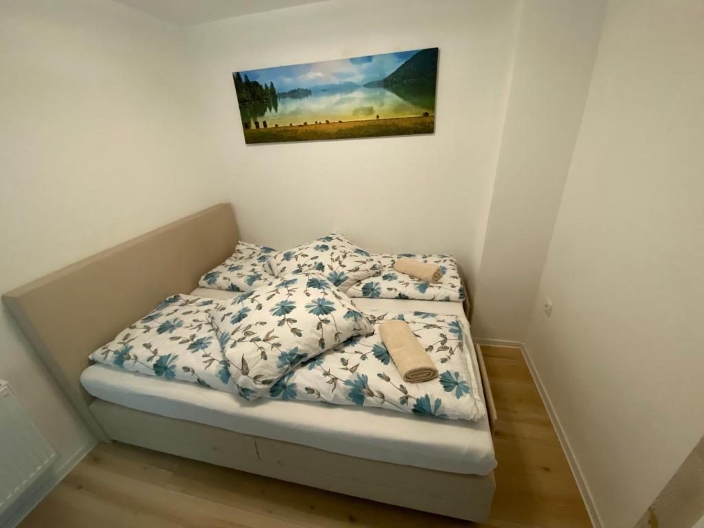 Lenne-Blick Ferienwohnung في Finnentrop: سرير صغير في غرفة نوم مع لوحة على الحائط