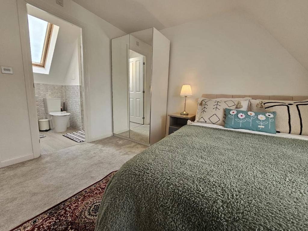 une chambre avec un grand lit et un miroir dans l'établissement Modern Bed at Bicester Village, Kingsmere, à Bicester