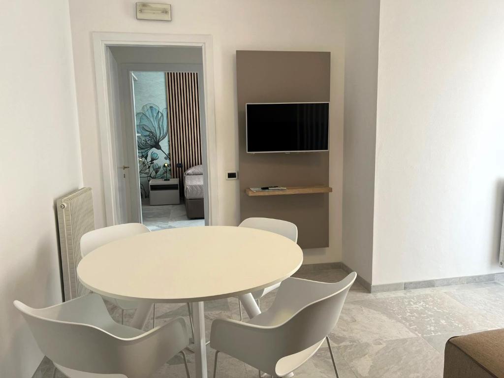 uma sala de jantar branca com uma mesa e cadeiras brancas em NUOVO Bilocale Design Piazza Aurora - Adria Holiday Immobiliare Jesolo - Family Apartments em Lido di Jesolo