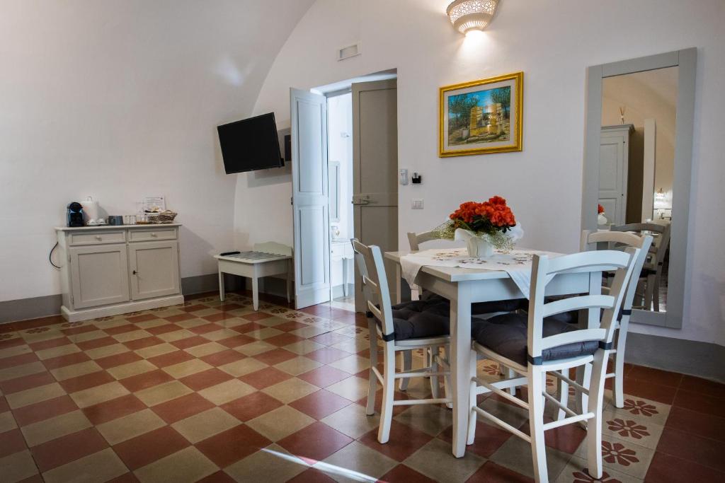 una cucina e una sala da pranzo con tavolo e sedie di Le Finestre Su Porta Carrese - Luxury Rooms & Suites a Matino