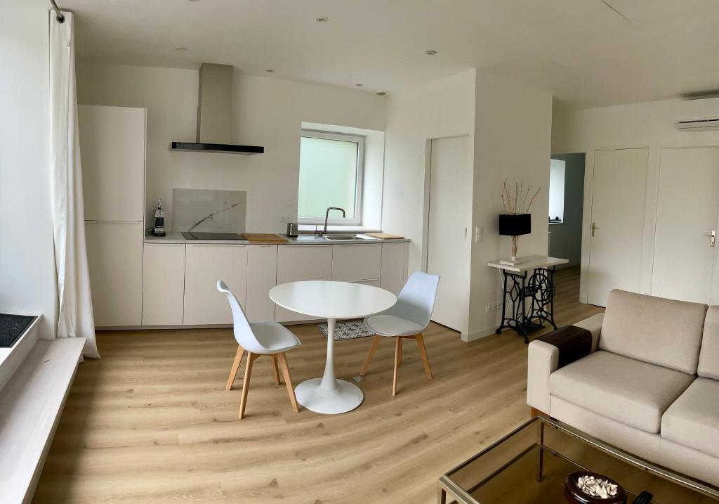 un salon avec une table, des chaises et un canapé dans l'établissement Petite maison au calme proche bourg, à Le Pener
