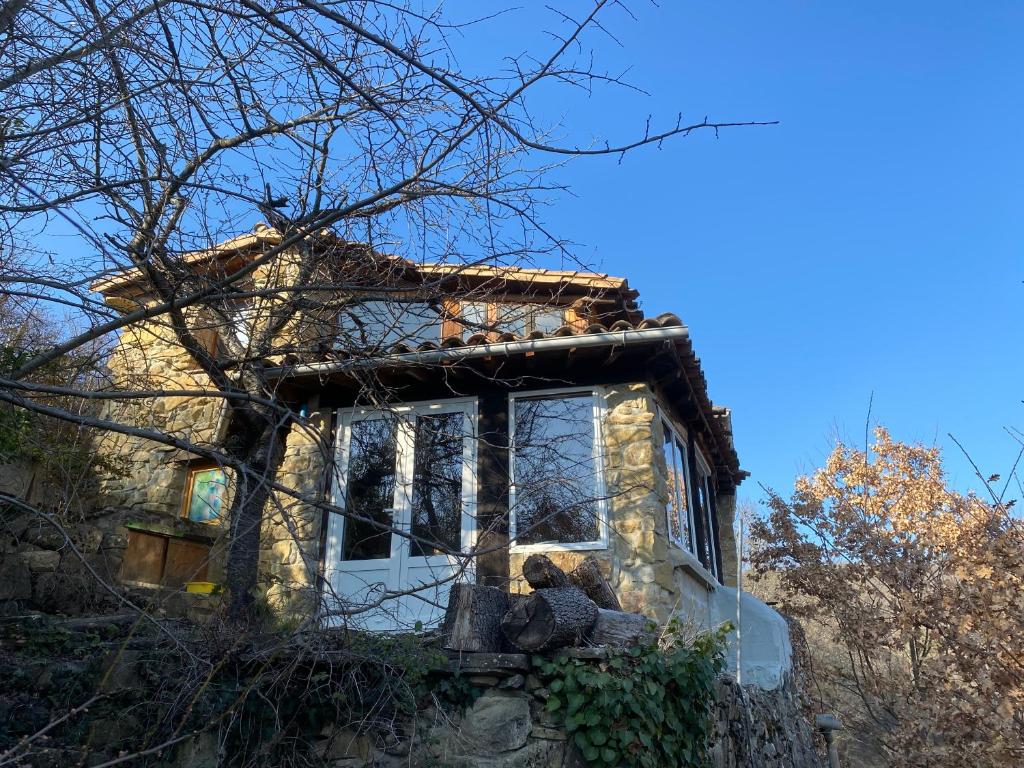une vieille maison avec un ours en peluche devant dans l'établissement La bergerie des étoiles, à Rouvenac