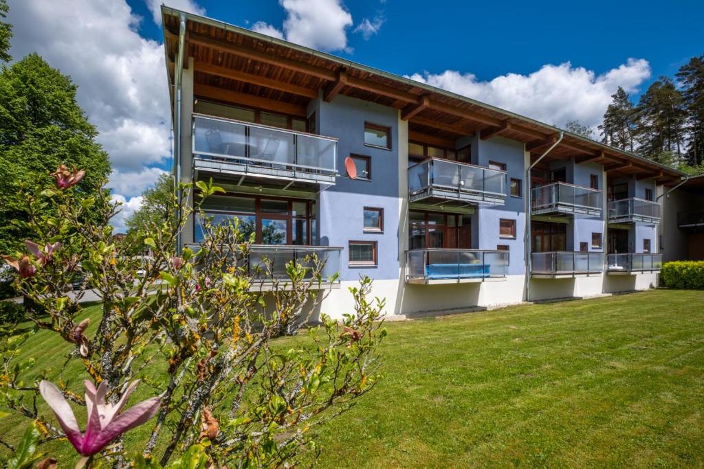 un edificio de apartamentos con balcones y patio en Apartment Doky D8 - Lipno Home en Lipno nad Vltavou