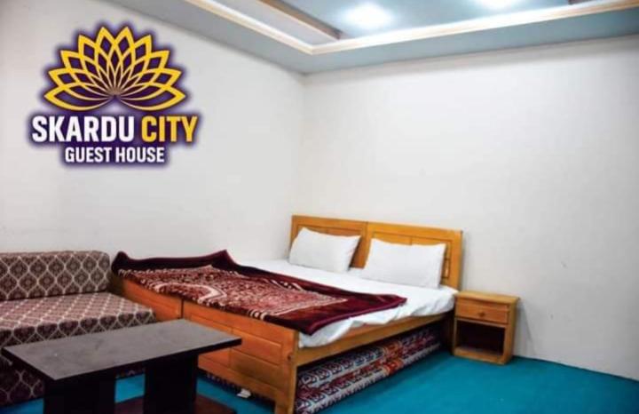 um quarto com uma cama e um sofá em Skardu city Guest house em Skardu