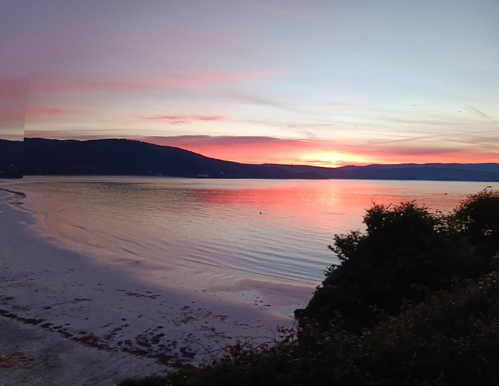 a sunset over a beach with the sun setting at Pension Doña Lubina in Finisterre