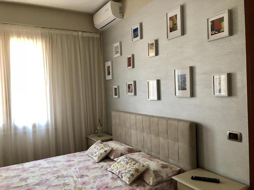 Schlafzimmer mit einem Bett mit Bildern an der Wand in der Unterkunft Giulietta Home in Belfiore