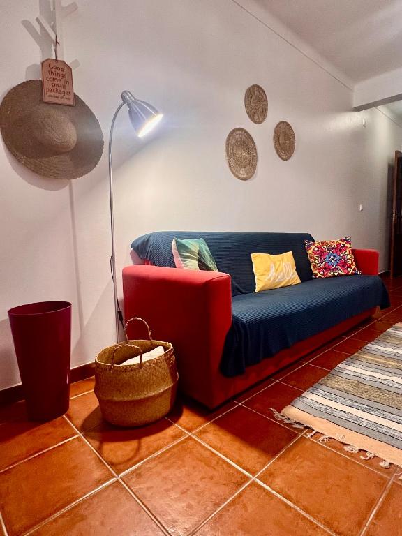 ein Wohnzimmer mit einem blauen Sofa und einer Lampe in der Unterkunft Escape House in Almograve