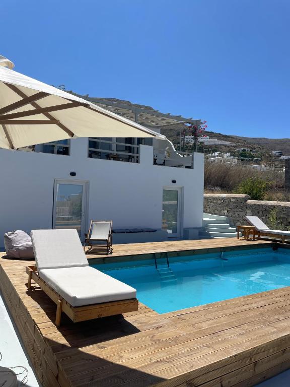 a villa with a swimming pool and a house at Minimal Grey Apartment Pool-front in Paros in Parikia