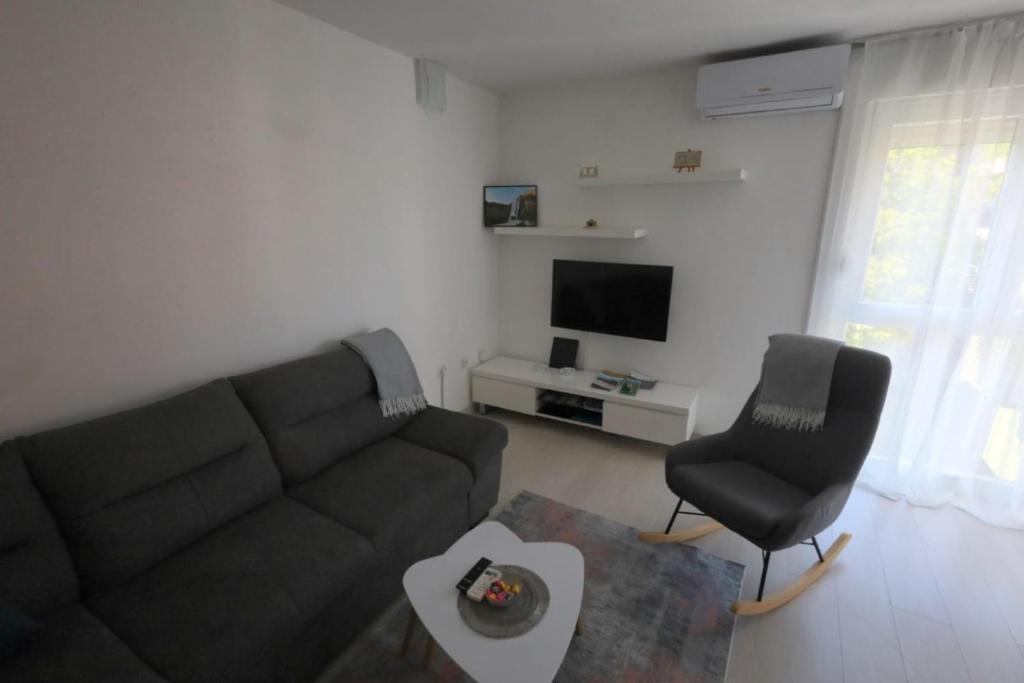 uma sala de estar com um sofá e uma cadeira em Apartment ZORA em Knin