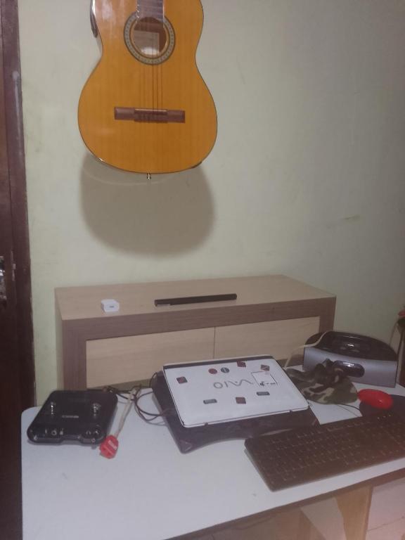 Pedro Juan CaballeroにあるCódigo 7の机の横に掛けられたギター