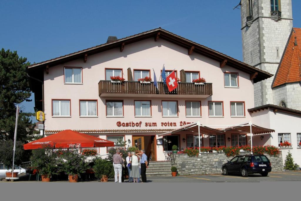 een groep mensen die voor een gebouw staan bij Hotel zum Roten Löwen in Hildisrieden