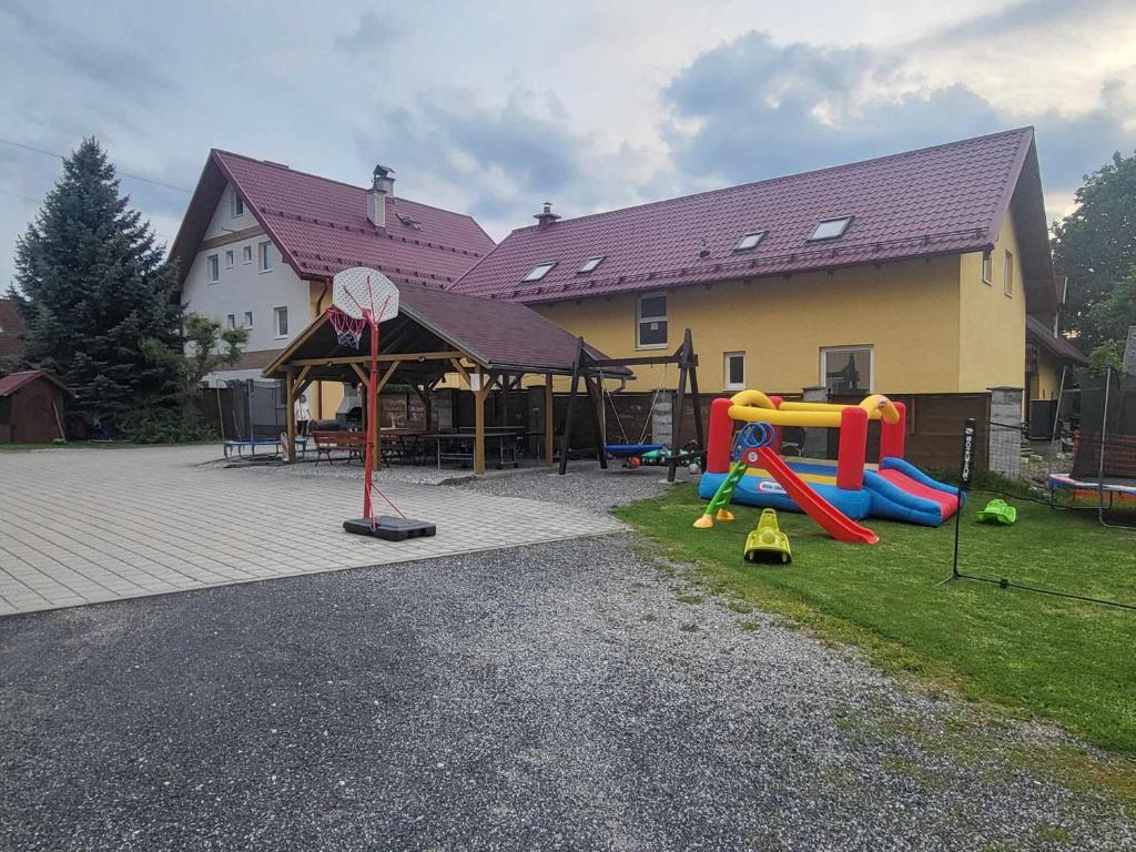 un parque infantil frente a una casa con un patio de juegos en Relax Jasna, en Liptovský Mikuláš