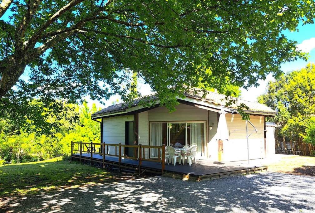 un petit chalet avec un porche et des chaises dessus dans l'établissement Bois d'été, à Saint-Julien-en-Born