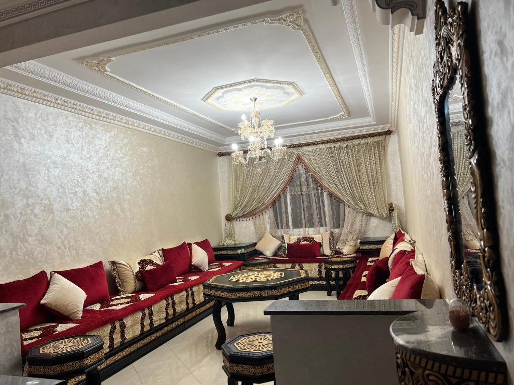 uma sala de estar com sofás vermelhos e um lustre em Appartement Tanger em Tânger