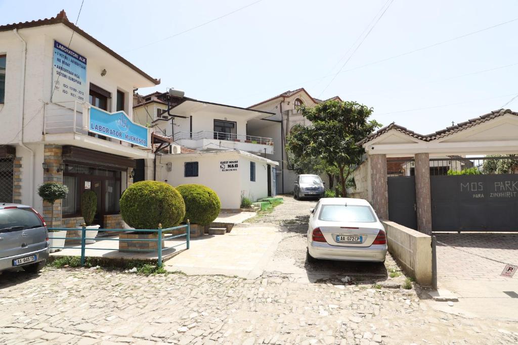 a car parked in a parking lot in front of a building at Guesthouse N&B in Berat