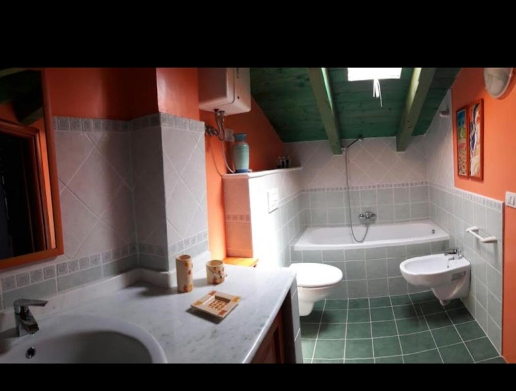 a bathroom with a sink and a toilet and a tub at La fontanella in Loceri