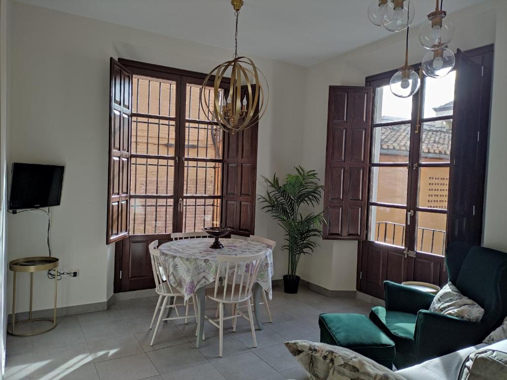 uma sala de estar com mesa e cadeiras em Granada Historic Center Apartment em Granada