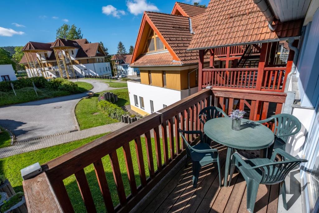 d'une terrasse avec une table et des chaises sur un balcon. dans l'établissement Apartmán Andy Riviera 503-10 Lipno Home, à Lipno nad Vltavou