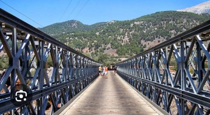 a group of people walking across a bridge at house FYNTIKAKH - SKALA in Anopoli Sfakion