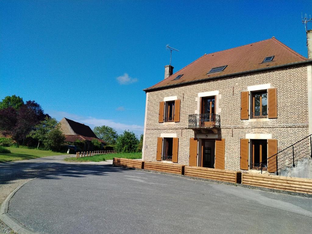 una gran casa de ladrillo con una carretera delante de ella en Au gîte Sérénité, en Mouthier-en-Bresse