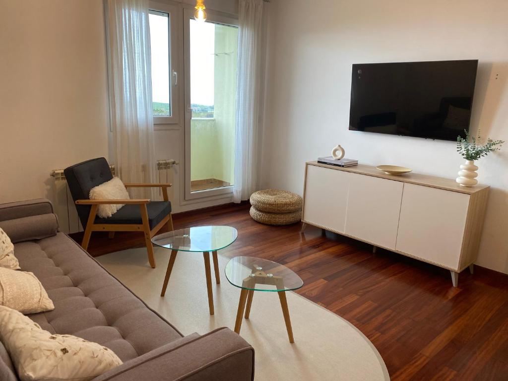 a living room with a couch and a flat screen tv at V&B VACACIONAL in Suances