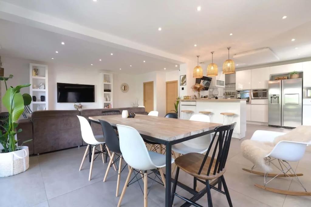 Il dispose d'une cuisine et d'un salon avec une table et des chaises en bois. dans l'établissement JO 2024 - Maison d'architecte avec jardin, à Villeneuve-la-Garenne