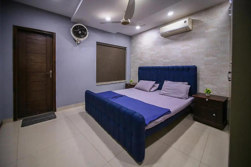1 dormitorio con 1 cama azul en una habitación en Hotel and apartments inn en Lahore
