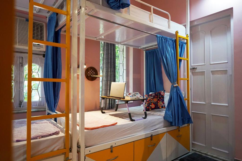 a bedroom with two bunk beds and a desk at The Nerd Nest Kolkata in Kolkata
