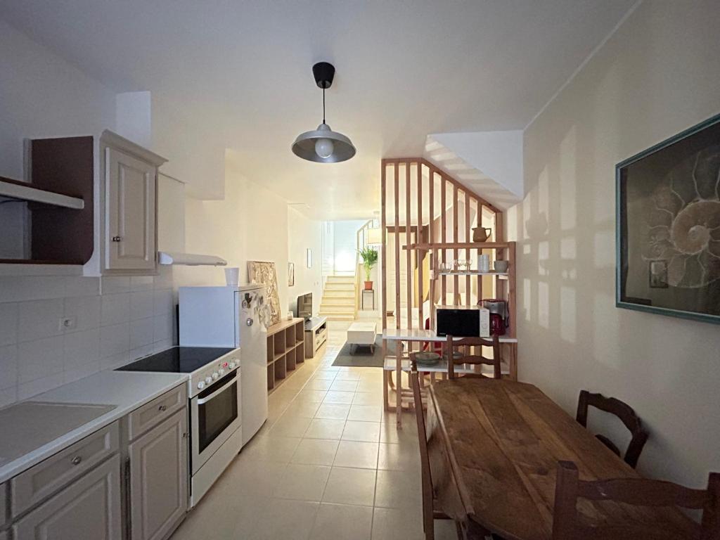 une cuisine avec une table en bois et une salle à manger dans l'établissement Maison 2chambres 3lits, à Nizas