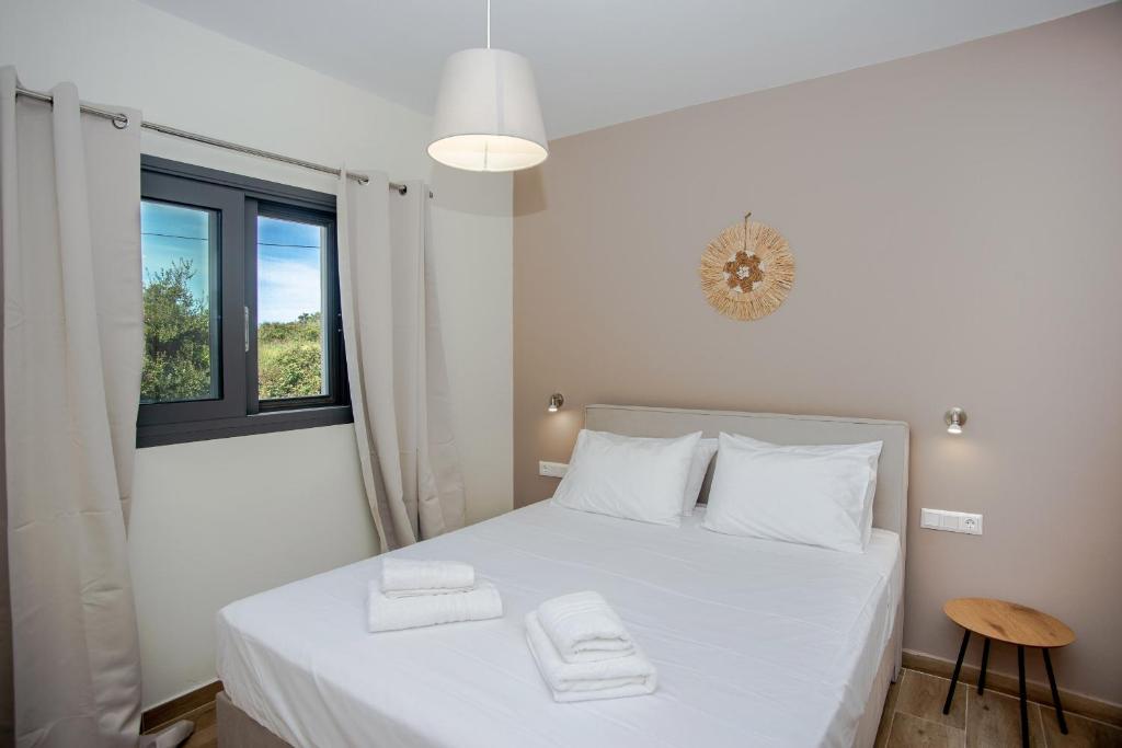 a bedroom with a white bed with two towels on it at Aella Apartment in Skala Kefalonias