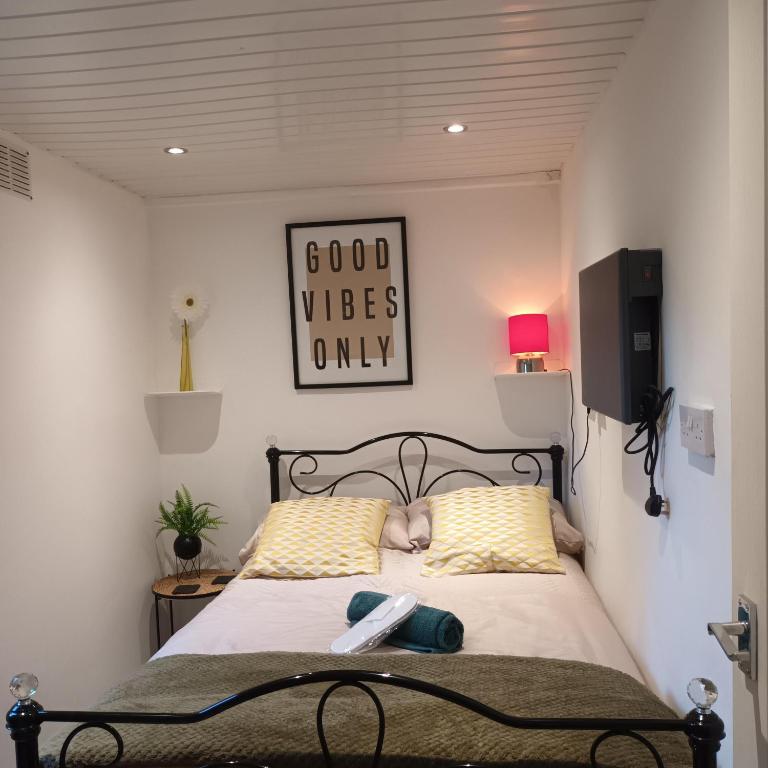 1 dormitorio con 1 cama con 2 almohadas amarillas en Le Hub - Roundhay Leeds - 1-Bed Studio Apartment, en Leeds