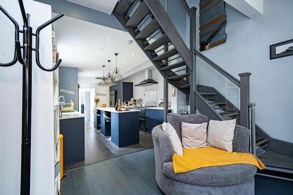 ein Wohnzimmer mit einem Stuhl und einer Treppe in der Unterkunft Hornsea Holiday House in Hornsea