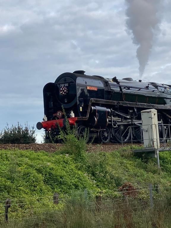 a black train is traveling down the tracks at Florita - Dawlish in Dawlish