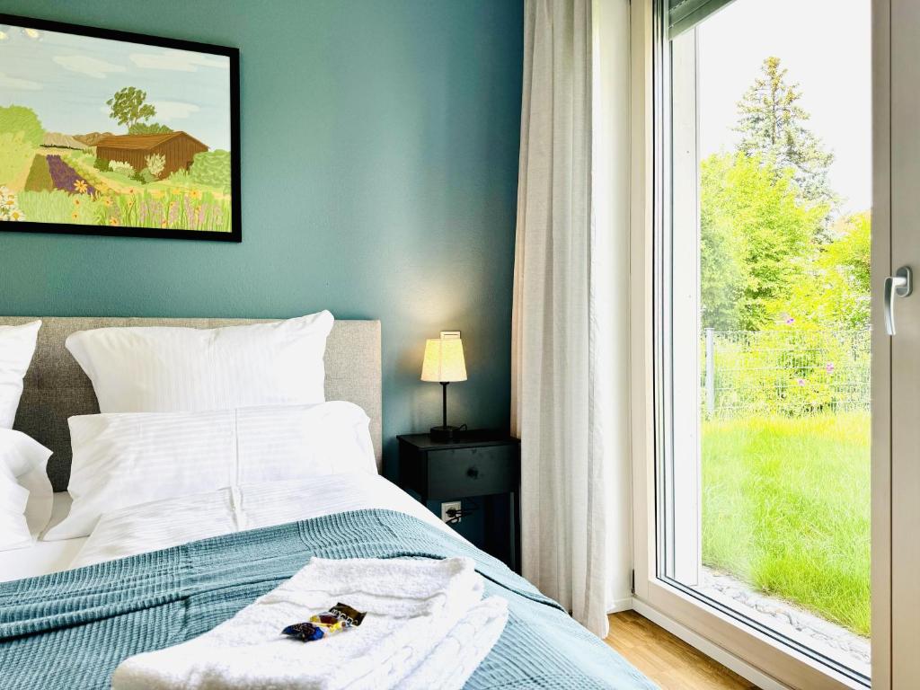 a bedroom with a bed and a large window at E&K living - design Apartments - SKY-TV - Audi - IN village - free parking in Ingolstadt