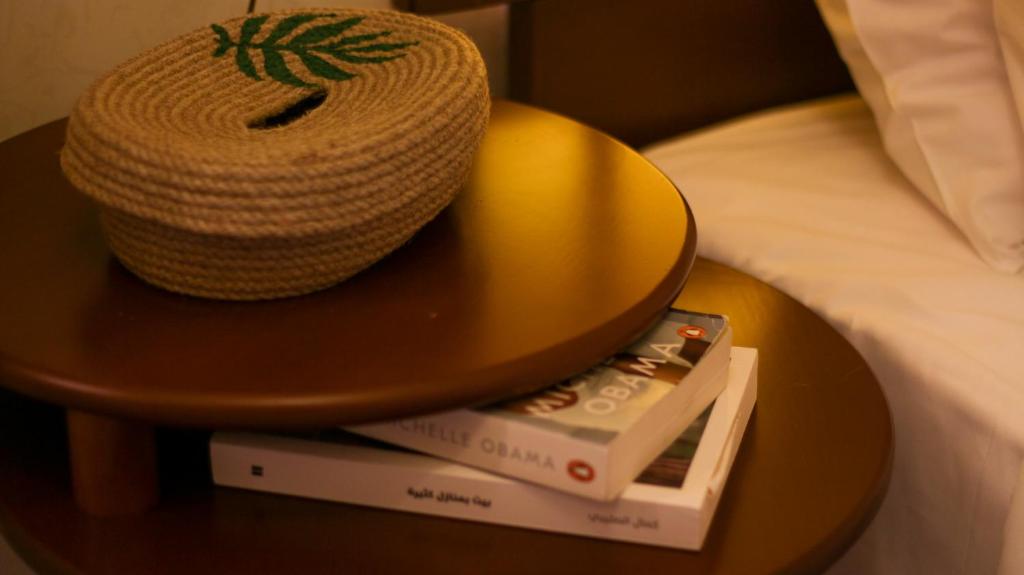 a table with a hat and a book on a bed at Beit Toureef in Beirut