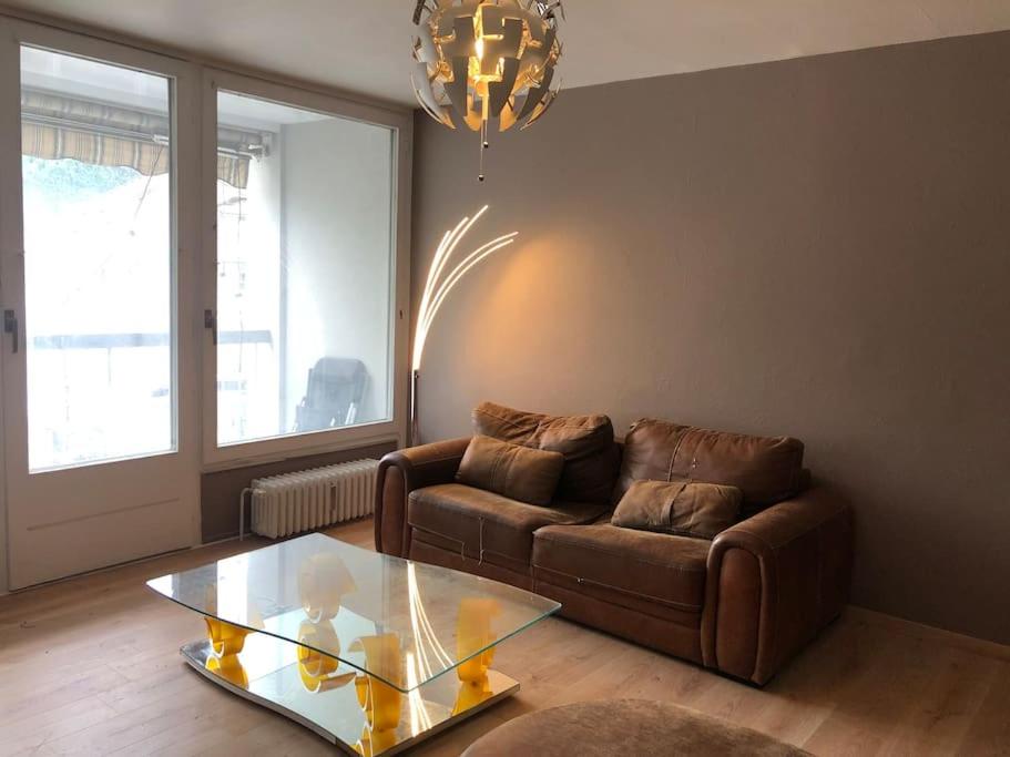 a living room with a couch and a glass table at Beau T2 rénové in Cluses