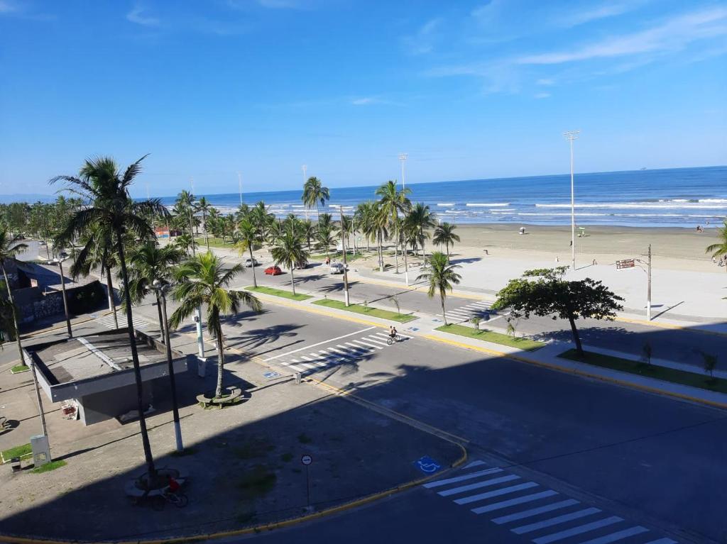 an empty street with palm trees and a beach at Apartamento Peruibe pé na areia!!! in Peruíbe