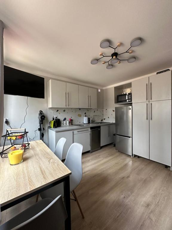 a kitchen with white cabinets and a table and chairs at Oto Domek 2 in Międzyrzecz