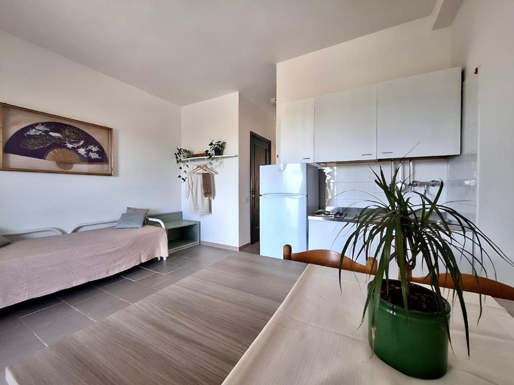 ein Wohnzimmer mit einem Kühlschrank und einer Topfpflanze in der Unterkunft Villa Amica in Vieste