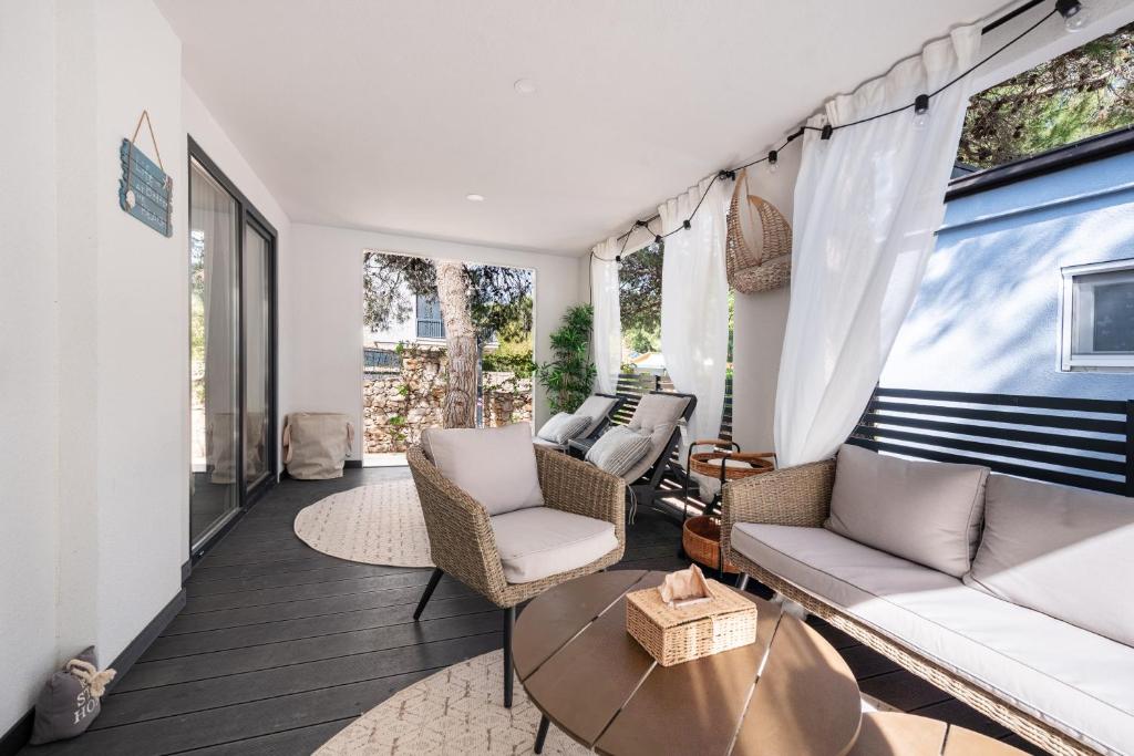 a living room with a couch and chairs and a table at Tiny home Rubi in Oaza Mira resort in Drage