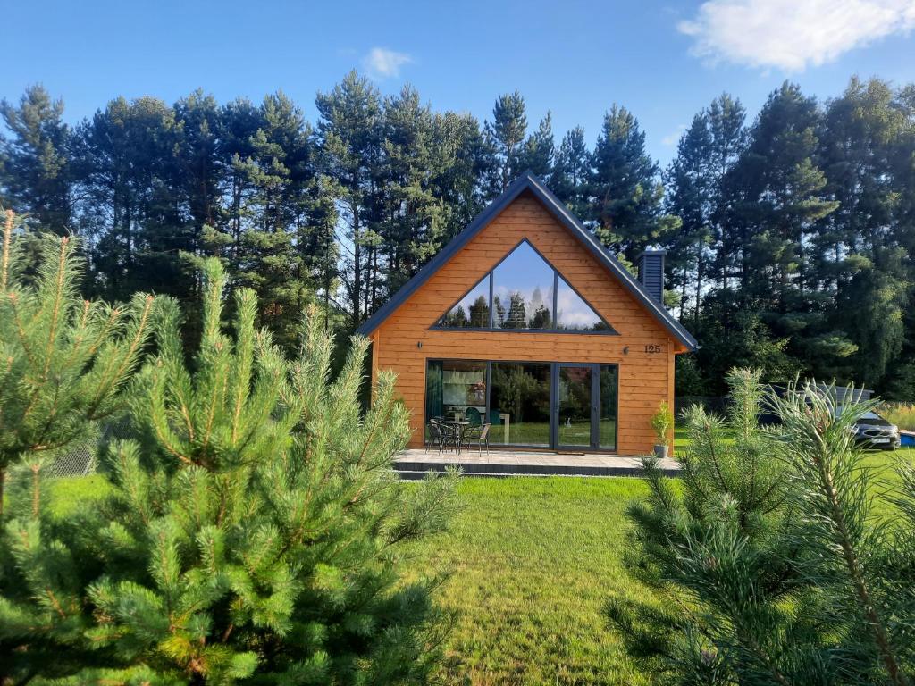 a house in the woods with a large window at Domek przy lesie na Roztoczu in AdamÃ³w