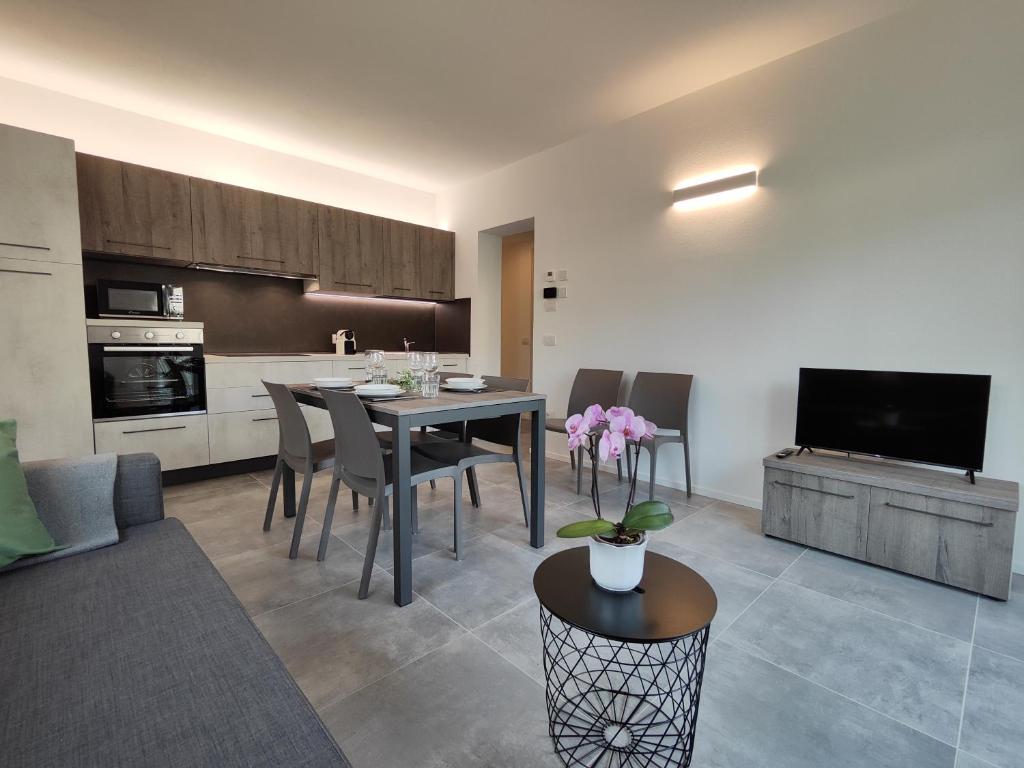 una cucina e un soggiorno con tavolo e sedie di Oasi degli Ulivi a Riva del Garda