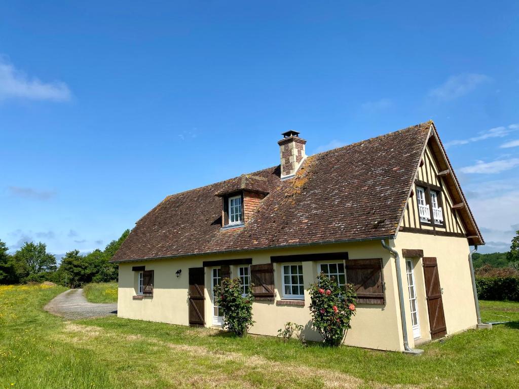 una antigua casa blanca con techo marrón en L'Etape Normande, en Sainte-Marguerite-des-Loges