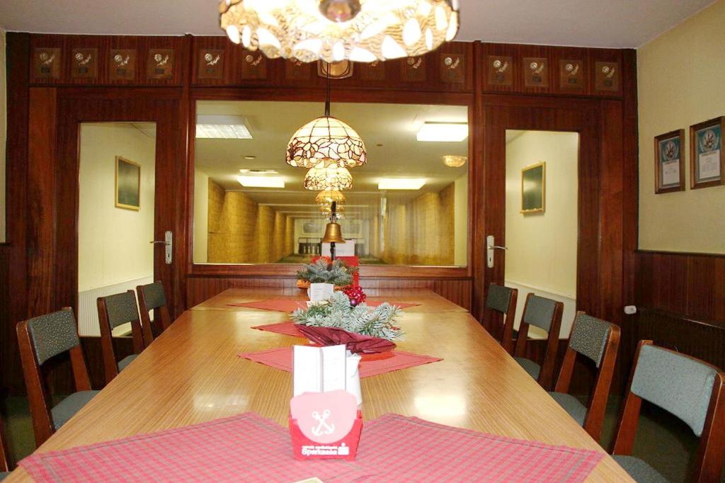 uma sala de jantar com uma mesa longa e um lustre em Döhling's Gasthaus em Morsum