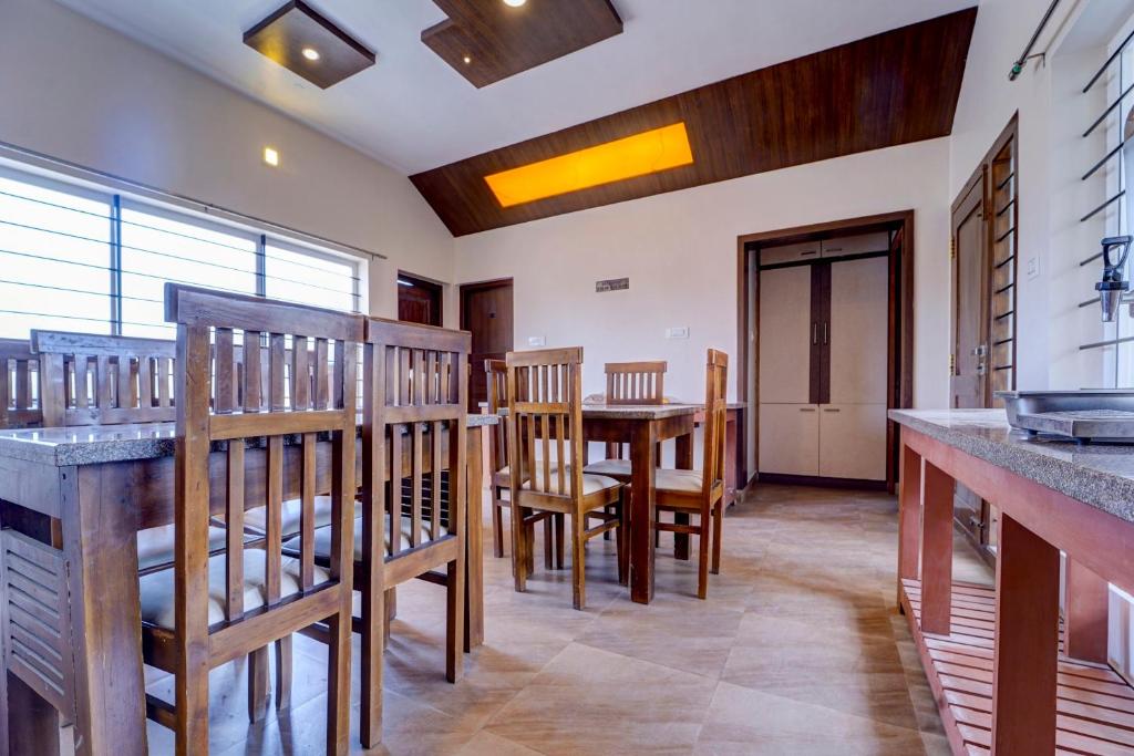 cocina con mesa y sillas en una habitación en Super OYO Collection O 81054 G Silver Srj Thaneesh Residency, en Ooty