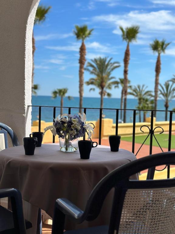 a table with a vase of flowers and palm trees at EL CANO MagicWorld MarinaDor in Oropesa del Mar