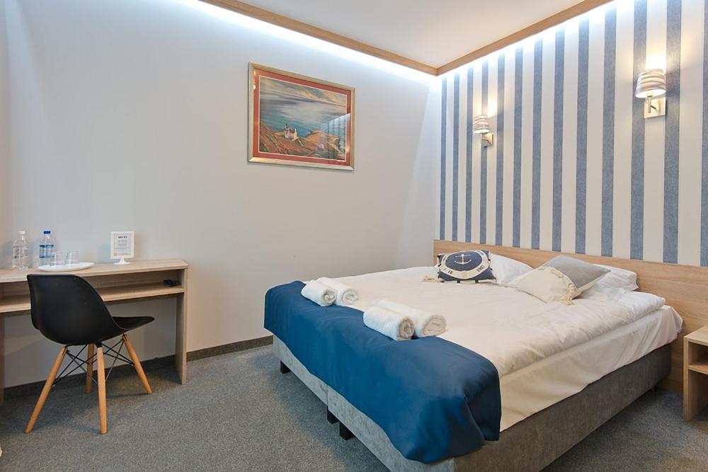 um quarto com uma cama, uma secretária e uma cadeira em B&B Molo em Sopot