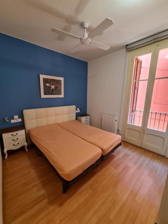 um quarto com uma cama e uma parede azul em Apartamentos Nouvilas em Portbou