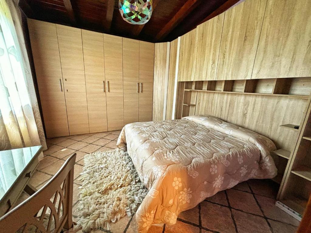 1 dormitorio con 1 cama con alfombra en el suelo en La casetta holiday en Fiumicino