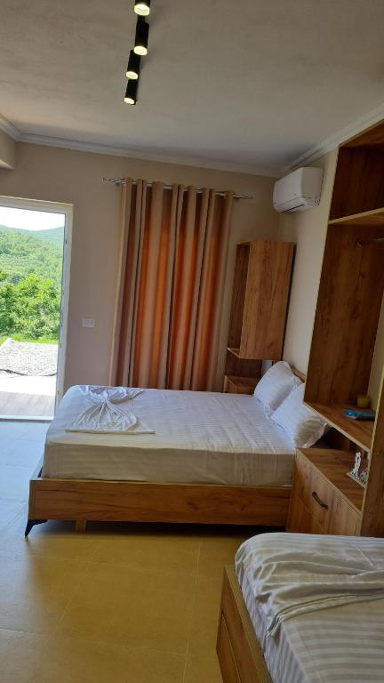 1 dormitorio con 2 camas y ventana grande en Sol Apartments Gjiri Lalzit en Durrës
